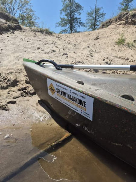 Kajak wyciągniety na brzeg piaszczystej wyspy